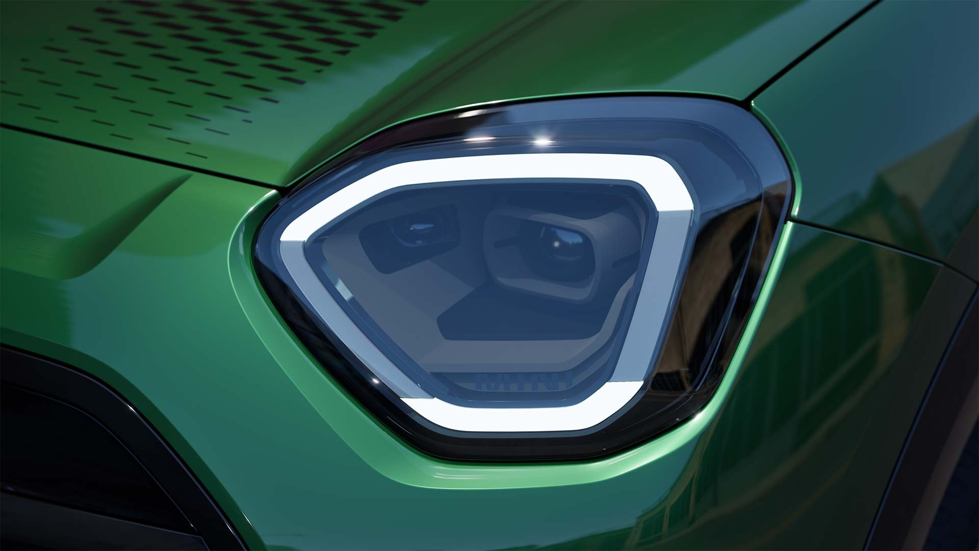 Detailansicht der Scheinwerfer des vollelektrischen MINI Aceman mit aktiviertem weissem Licht